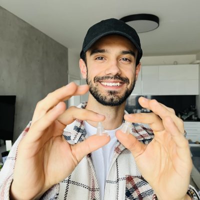 a man with a hat holding music soundpro earplugs